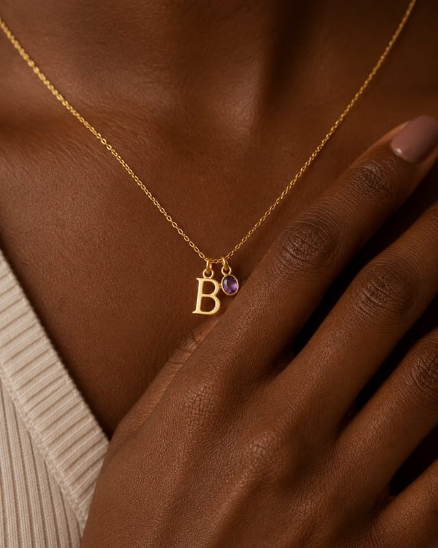 The initial letter necklace worn at the collarbone, letter B beside a purple stone