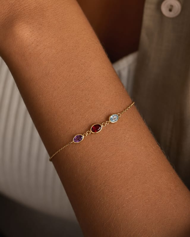 The three-stone birthstone bracelet worn on the wrist